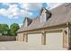 A three car garage with dormer windows above and brick exterior are featured in this exterior image at 101 Applecross Dr, Brownsburg, IN 46112