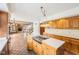 Open kitchen design with a central island, wood cabinets, and seamless flow into the living and staircase areas at 101 Applecross Dr, Brownsburg, IN 46112