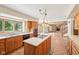 Bright kitchen showcasing a central island, wood cabinets, and a view into the spacious living area at 101 Applecross Dr, Brownsburg, IN 46112