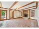 Spacious living room featuring tile flooring, beamed ceilings, and a charming brick fireplace for cozy gatherings at 101 Applecross Dr, Brownsburg, IN 46112