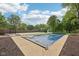 The backyard showcases a covered pool with slide and basketball court surrounded by trees, grass and landscaping at 101 Applecross Dr, Brownsburg, IN 46112