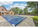 Backyard pool is covered, with a slide and ladder, next to a basketball court with green space on a sunny day at 101 Applecross Dr, Brownsburg, IN 46112