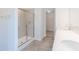 Modern bathroom with a glass-enclosed shower, dual sinks, neutral tiling, and a walk-in closet at 1107 Stubble Run, Danville, IN 46122