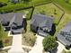 Aerial view of a home with a fenced backyard, lush green lawn, mature trees, and a driveway leading to a two-car garage at 11155 Funny Cide Dr, Noblesville, IN 46060
