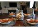 Dining table set with plates and decor; a view into living space with a fireplace at 11155 Funny Cide Dr, Noblesville, IN 46060