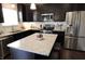 Modern kitchen featuring dark cabinetry, granite countertops, stainless steel appliances, and a center island with seating at 11155 Funny Cide Dr, Noblesville, IN 46060