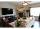 Cozy living room showcasing a stone fireplace, comfortable seating, a ceiling fan, and stylish decor at 11155 Funny Cide Dr, Noblesville, IN 46060