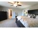 Large main bedroom featuring carpet floors, ceiling fan, and a view of the bathroom and closet at 11155 Funny Cide Dr, Noblesville, IN 46060