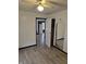 An open door leads to the closet in this bedroom with wood-look flooring and a ceiling fan at 114 S Catherwood Ave, Indianapolis, IN 46219