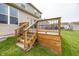 Wooden back deck with railing and stairs leading to the green, grassy backyard at 11818 Bellhaven Dr, Fishers, IN 46038