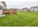 Expansive backyard with green grass and a wooden deck, perfect for outdoor entertaining at 11818 Bellhaven Dr, Fishers, IN 46038