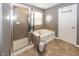 Bright bathroom with a glass-enclosed shower, soaking tub, and neutral tile surround plus a tile floor at 11818 Bellhaven Dr, Fishers, IN 46038