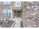 Inviting front entrance featuring a gray door with sidelight, decorative plants and charming brick facade at 11818 Bellhaven Dr, Fishers, IN 46038