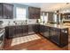 Well-lit kitchen area featuring stainless steel appliances, granite counters, and dark wooden cabinetry at 11818 Bellhaven Dr, Fishers, IN 46038