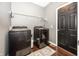 Modern laundry room features a new washer and dryer, a storage shelf, and a dark wood door at 11818 Bellhaven Dr, Fishers, IN 46038