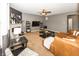 Comfortable living room featuring a fireplace, ceiling fan, and a plush, brown leather sectional sofa at 11818 Bellhaven Dr, Fishers, IN 46038