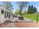 Backyard concrete patio area featuring a table and chairs with greenery and landscaping around the house at 1242 W Huntsville Rd, Pendleton, IN 46064