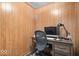 A wood paneled office space featuring a wood desk, computer, and black rolling chair at 1242 W Huntsville Rd, Pendleton, IN 46064