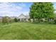 Large, grassy backyard overlooking a pond and landscaped with lush trees at 12739 Kiawah Dr, Carmel, IN 46033