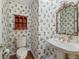 Charming powder room featuring floral wallpaper, an ornate mirror, and a pedestal sink at 12739 Kiawah Dr, Carmel, IN 46033