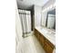 Well-lit bathroom featuring a double vanity, a shower and tub combo with curtains for privacy at 12974 Shandon Ln, Fishers, IN 46038
