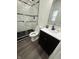Modern bathroom with a walk-in shower, wood-look flooring, and a sleek black vanity at 1327 Union St, Columbus, IN 47201