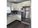 Modern kitchen with stainless steel refrigerator, sleek white cabinets, and stylish gray backsplash, blending form and function at 1327 Union St, Columbus, IN 47201