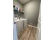 Laundry room with washer, dryer, shelving, and wood-look floors at 1380 Fairmount Dr, Greenfield, IN 46140