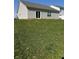 Expansive backyard with lush green grass, vinyl siding, and sliding glass door access to the house at 142 Winding Brook Way, Pendleton, IN 46064