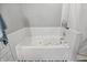 Bathroom featuring white soaking tub with white tile surround and a gray painted wall at 14634 Village Park East Dr, Carmel, IN 46033