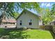 Charming home exterior with a well-manicured lawn, landscaped garden bed, and a partial view of the fenced yard at 14634 Village Park East Dr, Carmel, IN 46033