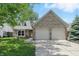 Charming brick home featuring a two-car garage, dormer windows, and manicured lawn at 14634 Village Park East Dr, Carmel, IN 46033