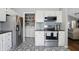 Open kitchen featuring stainless appliances, black counters and adjacent laundry room for convenience at 14634 Village Park East Dr, Carmel, IN 46033