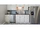 Well-lit kitchen showcasing stainless steel appliances, black counters, and decorative tile floors at 14634 Village Park East Dr, Carmel, IN 46033