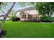 Beautiful backyard featuring a spacious lawn, mature trees, and a wooden deck at 14707 Thor Run Dr, Fishers, IN 46040