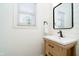 Stylish bathroom showcasing a wood vanity and a modern mirror, complemented by a window for bright, natural light at 14707 Thor Run Dr, Fishers, IN 46040