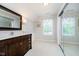 Bright bathroom featuring a single vanity, a large mirror, and a window for natural lighting at 14707 Thor Run Dr, Fishers, IN 46040