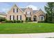 Charming brick and stone home with a lush green lawn and professionally landscaped front yard at 14707 Thor Run Dr, Fishers, IN 46040