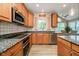 Well-lit kitchen with stainless steel appliances, granite countertops, tile backsplash and access to a dining area at 14707 Thor Run Dr, Fishers, IN 46040