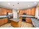 Functional kitchen featuring an island, wood cabinets, stainless steel appliances, and granite countertops at 14707 Thor Run Dr, Fishers, IN 46040