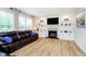 Cozy living room with a fireplace, built-in shelving, large windows and comfortable leather seating at 14707 Thor Run Dr, Fishers, IN 46040