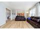 Open concept living room showing kitchen access with hardwood floors and comfortable leather seating at 14707 Thor Run Dr, Fishers, IN 46040