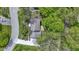 An aerial view showing the house with a wood deck, driveway, mature trees, and landscaping at 16 Maplecrest Dr, Carmel, IN 46033