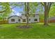 Expansive backyard featuring lush lawn, mature trees, and a wood deck, perfect for outdoor entertaining at 16 Maplecrest Dr, Carmel, IN 46033