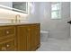 Bathroom features a wood cabinet, marble countertop and backsplash, toilet, and window at 16 Maplecrest Dr, Carmel, IN 46033
