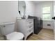 Modern bathroom with sleek vanity, oval mirror, washer, and dryer at 16 Maplecrest Dr, Carmel, IN 46033