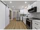 Open kitchen featuring stainless steel appliances, white cabinetry, and stone backsplash at 16 Maplecrest Dr, Carmel, IN 46033