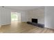Bright living room featuring hardwood floors, a decorative stone fireplace, and backyard access at 16 Maplecrest Dr, Carmel, IN 46033
