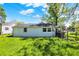 Backyard with green grass, scattered trees, a house with white siding and a chain link fence at 1610 S F St, Elwood, IN 46036
