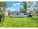 Backyard with green grass, scattered trees, a house with white siding and a chain link fence at 1610 S F St, Elwood, IN 46036